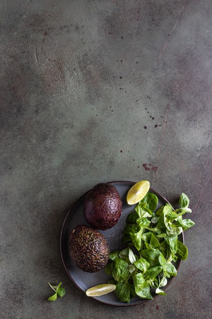 Avocado groene bladeren salade en limoenschijfjes gezonde vetten bovenaanzicht kopieer de ruimte