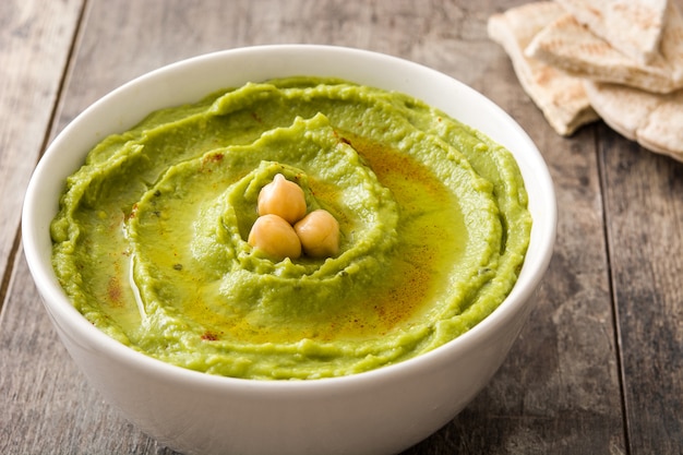 Avocado hummus in kom op houten tafel