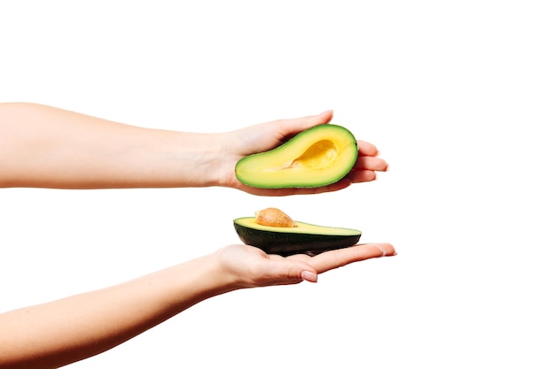 avocado in een vrouwelijke hand op een witte achtergrond