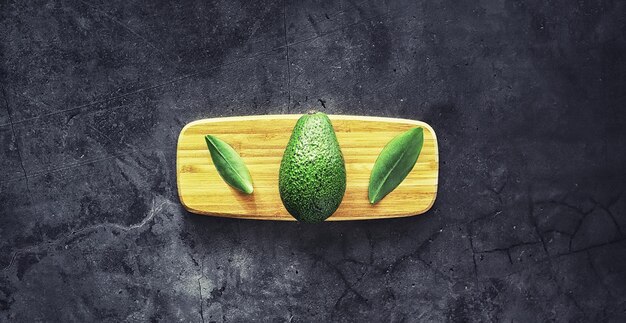 Avocado kookrecepten. rijpe groene avocado op een houten snijplank om te serveren.