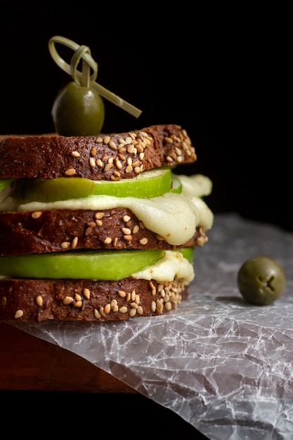 Avocado and melted cheese toast sandwich with olives