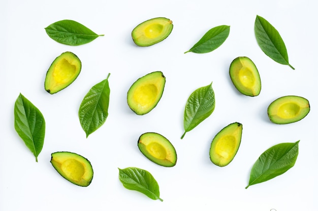 Avocado met groene bladeren op witte achtergrond. Bovenaanzicht