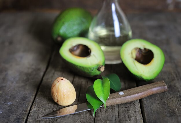 Avocado e olio su fondo in legno