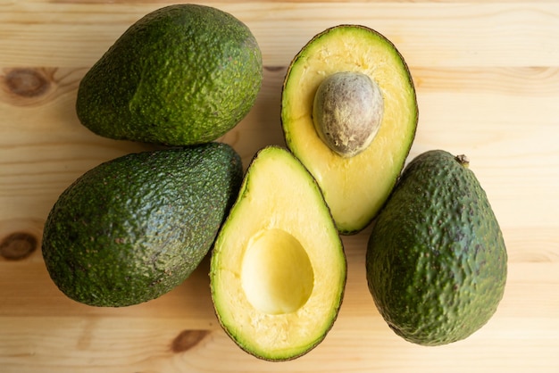 Avocado op hout achtergrond Avocado fruit Rauw fruit gezond groen voedsel Hele en halve avocado