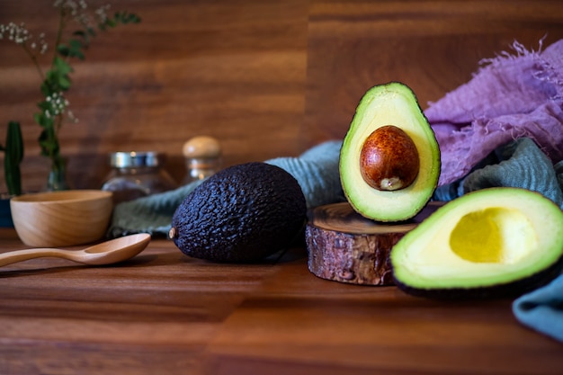 Avocado op houten tafel. Snijd avocado&#39;s op een snijplank. Vruchten gezond voedselconcept.