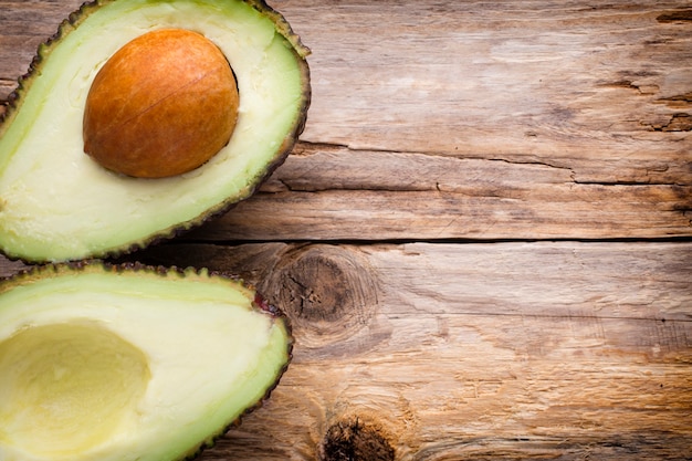 Avocado parts on the wooden table.