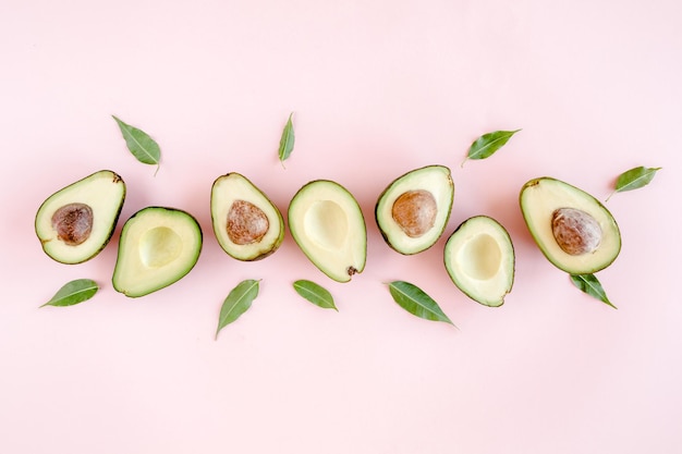 Avocado on pink background tropical abstract background with avocado food concept flat lay top view