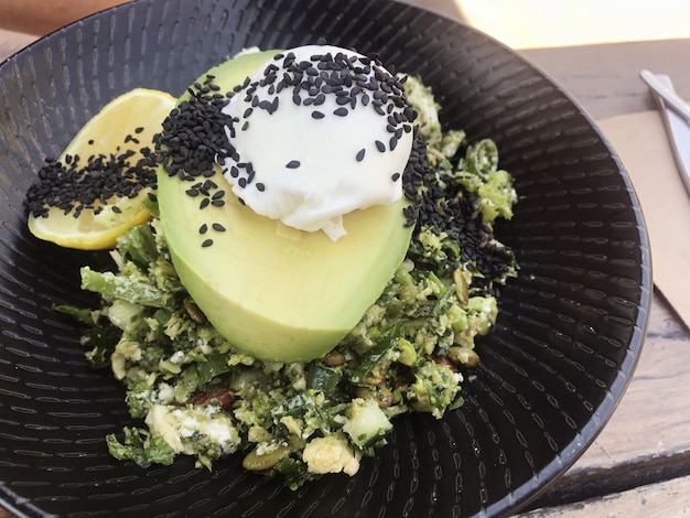 Avocado, poached egg with green salad, healthy vegetarian meal, ketogenic food