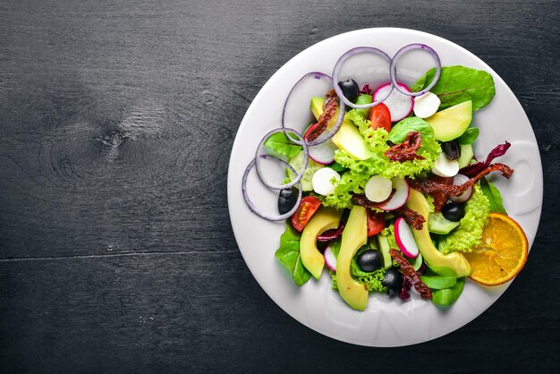 Insalata di avocado con carne alla griglia e verdure cucina italiana vista dall'alto su fondo in legno