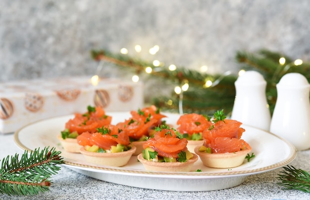 Antipasto di avocado e salmone sulla tavola di capodanno. tartellette con pesce.