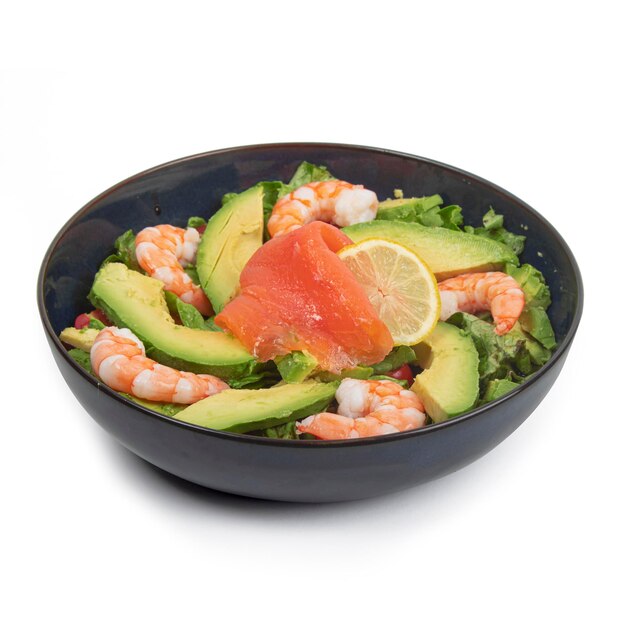 Avocado salmon shrimp salad in a blue plate on a white background