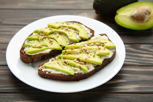 Panino di avocado su pane di segale scuro fatto con avocado affettato fresco