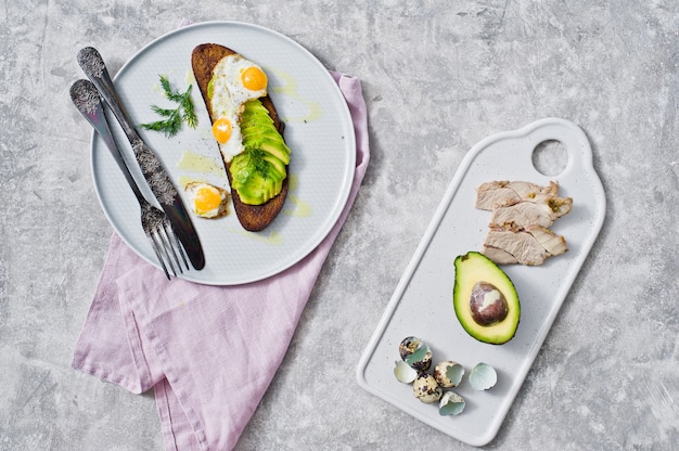 Avocado sandwich with egg on a gray plate.