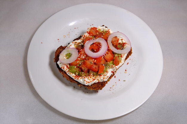 Бутерброды с авокадо половина авокадо с арахисом и семенами тыквы луковые кольца красный перец на белом фоне