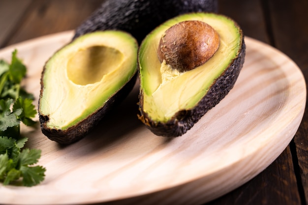 Avocado split in half on wood. Healthy and vegetarian food