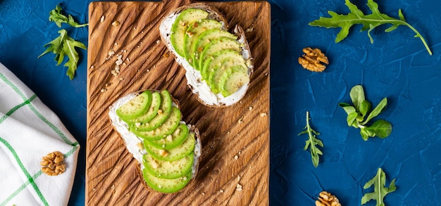 Avocado toast voor ontbijt of lunch met roggebrood pompoenpitten Vegetarisch eten bovenaanzicht met kopieerruimte