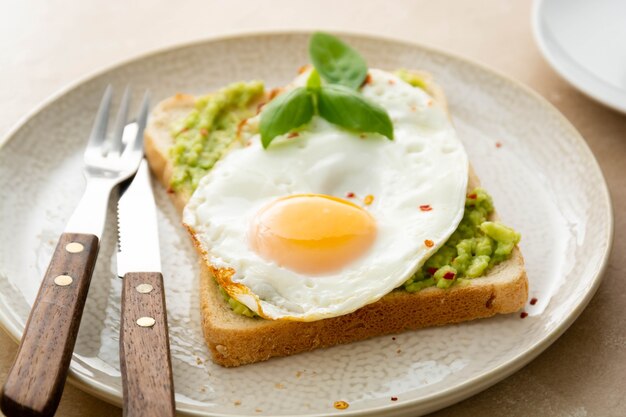 Avocado toast with fried eggs and fresh green peas, ccoffee cups. Healthy breakfast, keto food. Dieting concept.