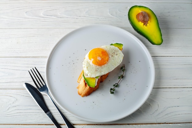 Avocado toast with melted cheese and scrambled eggs