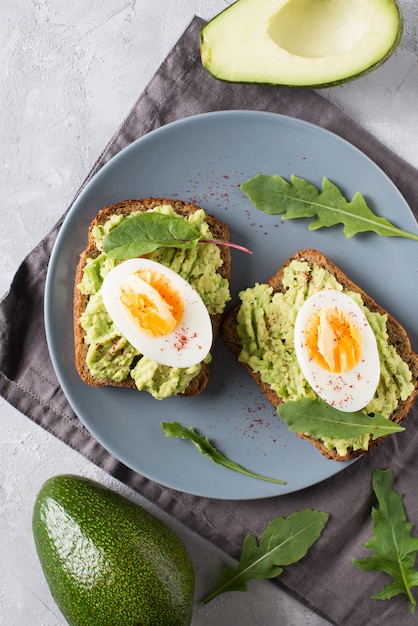 Avocado toasts with eggs and salad on breakfast, clean food