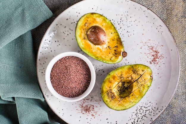 Avocado with black salt kala namak on a plate on the table Top view Closeup