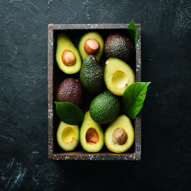 Photo avocado with leaves in the box rustic style top view free space for your text