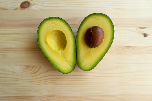 Avocado on wood background avocado fruit raw fruits healthy\
green food whole and half avocado