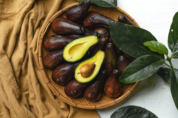 나무 쟁반에 있는 아보카도 건강 식품 갈색 배경