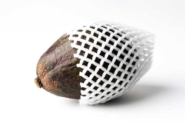 Avocado wrapped in foam mesh isolated on a white background, the flesh of the avocado is creamy and soft with a buttery taste. Avocados contain nutrients, vitamins and good fats.