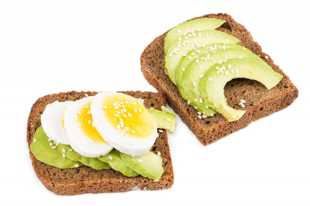 Avocadoplakken en eieren op roggebrood met sesam