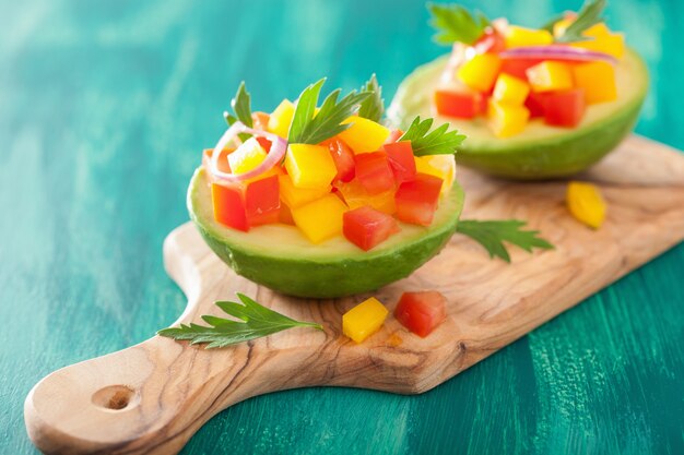 Foto avocado ripieni di insalata di peperoni e pomodoro