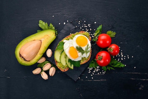 Avocadosandwich met kwarteleitjes, komkommer en pistachenoten Op een houten ondergrond Bovenaanzicht Vrije ruimte voor uw tekst