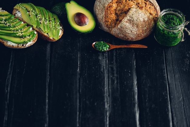 Avocadosandwich op donker roggebrood gemaakt met vers gesneden avocado's van bovenaf. Copyspace voor uw tekst