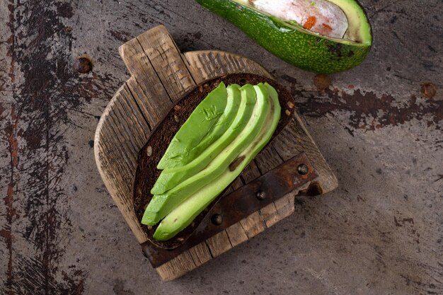 Avocadosandwich op houten plank vintage ijzeren achtergrond