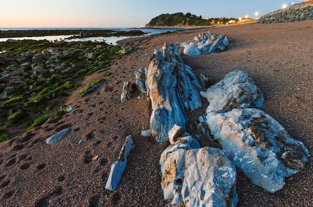 Avond oceaan kust uitzicht vanaf strand met grote stenen (in de buurt van Saint-Jean-de-Luz, Frankrijk, Golf van Biskaje).