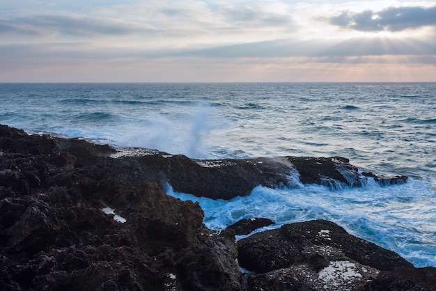 Avond zeegezicht uitzicht vanaf de kust met zonnestralen in bewolkte hemel