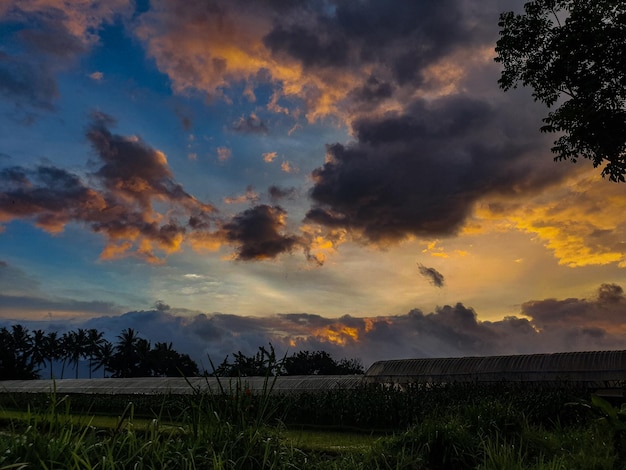Avondlucht met dramatische wolken boven de boerderij en dramatische zonsondergang boven de boerderij