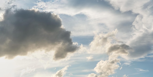 Avondlucht met wat gele, witte, grijze en donkere wolken