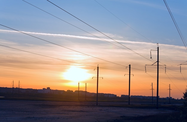 Avondrood boven de stad en hoogspanningslijn