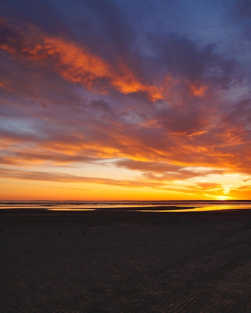 Avondrood met reflecties in waterzonlicht en gekleurde oranje wolken