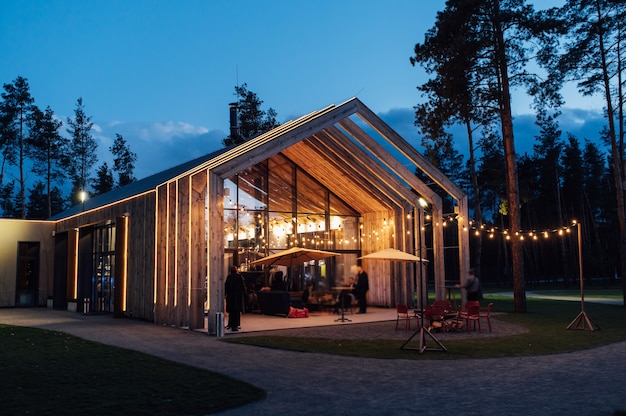 Avondverlichting op de binnenplaats met de achtergrond van een modern houten huis