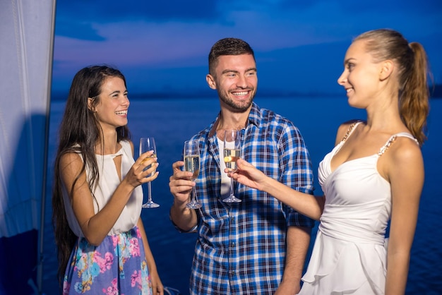 Avondwandeling op het meer vrienden vieren verjaardag jonge mensen met glazen champagne jeugd p