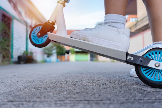 Avontuur voor het leerconcept van kinderen Door scooters te gebruiken om te reizen om nieuwe dingen in het leven te vinden Close-up van de voet die naar de bovenkant van de scooters kijkt