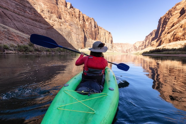 Avontuurlijke vrouw op een kajak die in de rivier van Colorado peddelt