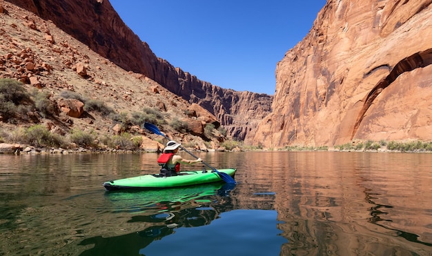 Avontuurlijke vrouw op een kajak die peddelt in de Colorado River Glen Canyon, Arizona