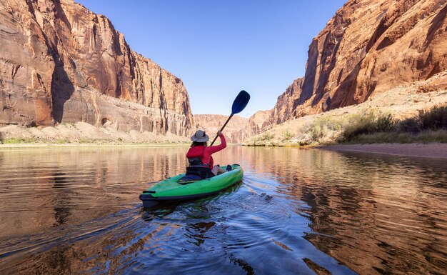 Avontuurlijke vrouw op een kajak die peddelt in de Colorado River Glen Canyon, Arizona