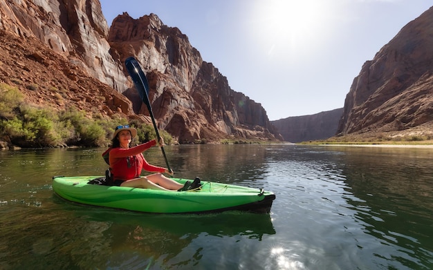 Avontuurlijke vrouw op een kajak die peddelt in de Colorado River Glen Canyon, Arizona