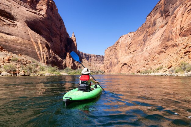 Avontuurlijke vrouw op een kajak die peddelt in de Colorado River Glen Canyon, Arizona