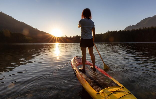 Foto avontuurlijke vrouw peddelend op een paddleboard in een vredig meer