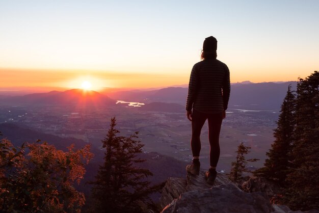 Avontuurlijke vrouw wandelen in het Canadese landschap met herfstkleuren tijdens zonnige zonsondergang