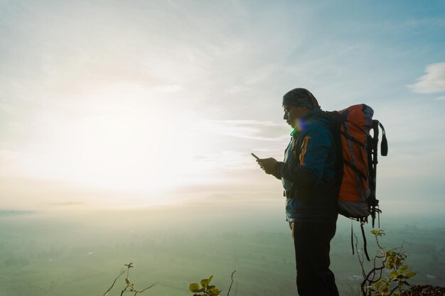 驚く べき 景色 ヒスパニック 人 の 男性 が 山 を 登る 際 に 壮大な 日の出 を 観察 し て いる